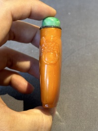 A rare Chinese amber lion-handled snuff bottle, 19th C.