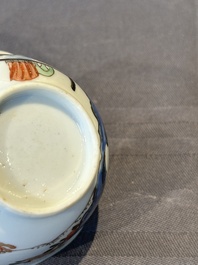 A Chinese polychrome cup and saucer with figures and a dog, Yongzheng