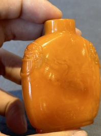A rare Chinese amber lion-handled snuff bottle, 19th C.