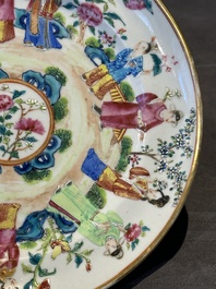 A pair of Chinese Canton famille rose plates with figures in a garden, 19th C.