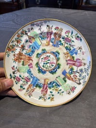 A pair of Chinese Canton famille rose plates with figures in a garden, 19th C.