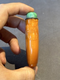 A rare Chinese amber lion-handled snuff bottle, 19th C.