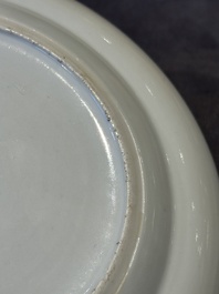 A pair of Chinese Canton famille rose plates with figures in a garden, 19th C.
