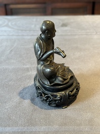 A small Chinese bronze figure of a Luohan, Ming