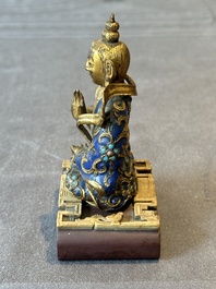 A Chinese gilt and champlev&eacute; enamelled bronze Bodhisattva on a carved stone stand, Qing