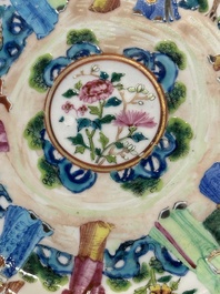 A pair of Chinese Canton famille rose plates with figures in a garden, 19th C.