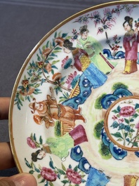 A pair of Chinese Canton famille rose plates with figures in a garden, 19th C.