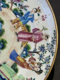 A pair of Chinese Canton famille rose plates with figures in a garden, 19th C.