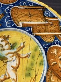 A polychrome Italian maiolica plate with a putto surrounded by trophies, Pesaro, 16th C.