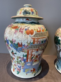 A pair of Chinese famille rose 'hundred boys' vases and covers on wooden stands, 19th C.