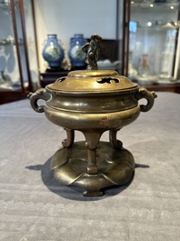A Chinese bronze tripod censer with cover and stand, 19th C.