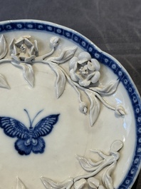 A Chinese blue and white 'butterfly' cup and saucer with applied floral design, Qianlong
