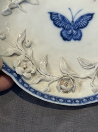 A Chinese blue and white 'butterfly' cup and saucer with applied floral design, Qianlong