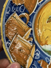 A polychrome Italian maiolica plate with a putto surrounded by trophies, Pesaro, 16th C.