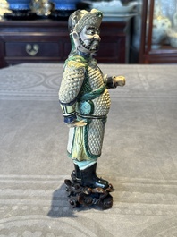 A fine Chinese verte biscuit figure of a warrior on wooden stand, Kangxi