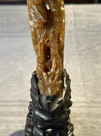 A Chinese buffalo horn carving of a landscape with a pagoda on wooden stand, Qing