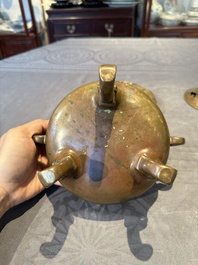 A Chinese bronze tripod censer with cover and stand, 19th C.