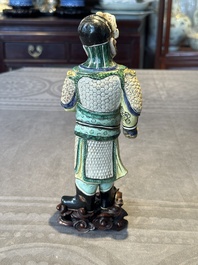 A fine Chinese verte biscuit figure of a warrior on wooden stand, Kangxi