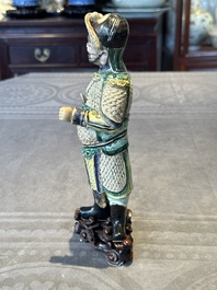 A fine Chinese verte biscuit figure of a warrior on wooden stand, Kangxi