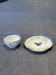 A Chinese blue and white 'butterfly' cup and saucer with applied floral design, Qianlong