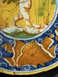 A polychrome Italian maiolica plate with a putto surrounded by trophies, Pesaro, 16th C.