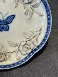 A Chinese blue and white 'butterfly' cup and saucer with applied floral design, Qianlong