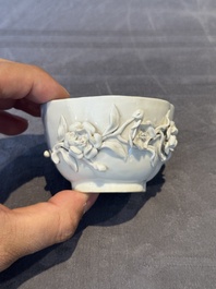 A Chinese blue and white 'butterfly' cup and saucer with applied floral design, Qianlong