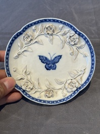 A Chinese blue and white 'butterfly' cup and saucer with applied floral design, Qianlong