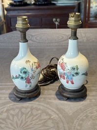 A pair of Chinese famille rose vases with figural design mounted as lamps, 19th C.