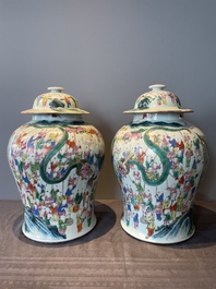 A pair of Chinese famille rose 'hundred boys' vases and covers on wooden stands, 19th C.