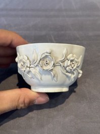 A Chinese blue and white 'butterfly' cup and saucer with applied floral design, Qianlong