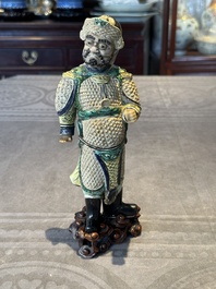 A fine Chinese verte biscuit figure of a warrior on wooden stand, Kangxi
