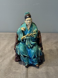 A Chinese turquoise- and aubergine-glazed sculpture of a seated scholar, 18/19th C.
