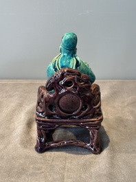 A Chinese turquoise- and aubergine-glazed sculpture of a seated scholar, 18/19th C.