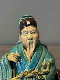 A Chinese turquoise- and aubergine-glazed sculpture of a seated scholar, 18/19th C.