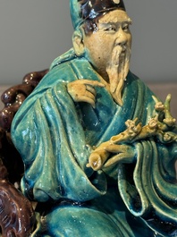 A Chinese turquoise- and aubergine-glazed sculpture of a seated scholar, 18/19th C.