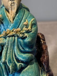 A Chinese turquoise- and aubergine-glazed sculpture of a seated scholar, 18/19th C.