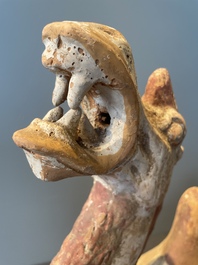 A pair of Chinese polychrome-painted terracotta camels with saddles, Tang