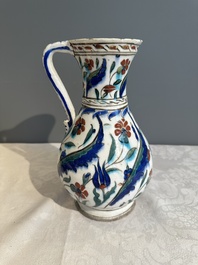 A polychrome and gilt Iznik ewer with tulips, carnation flowers and saz leaves, Turkey, ca. 1600