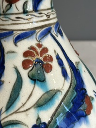 A polychrome and gilt Iznik ewer with tulips, carnation flowers and saz leaves, Turkey, ca. 1600
