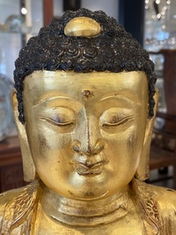 A large Sino-Tibetan gilt bronze Buddha on wooden stand, Ming