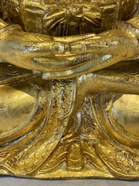 A large Sino-Tibetan gilt bronze Buddha on wooden stand, Ming
