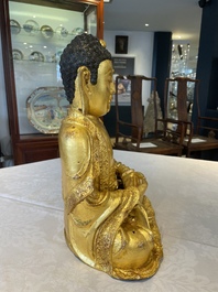 A large Sino-Tibetan gilt bronze Buddha on wooden stand, Ming