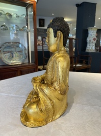 A large Sino-Tibetan gilt bronze Buddha on wooden stand, Ming