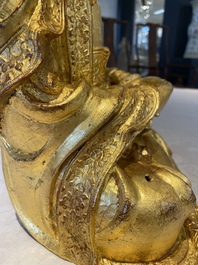 A large Sino-Tibetan gilt bronze Buddha on wooden stand, Ming
