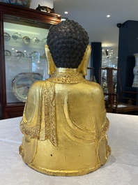 A large Sino-Tibetan gilt bronze Buddha on wooden stand, Ming