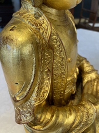 A large Sino-Tibetan gilt bronze Buddha on wooden stand, Ming