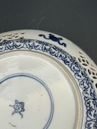 A pair of Chinese blue and white plates with floral design and reticulated border, conical shell mark, Kangxi