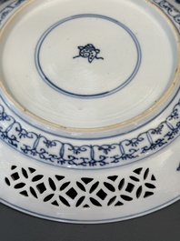 A pair of Chinese blue and white plates with floral design and reticulated border, conical shell mark, Kangxi