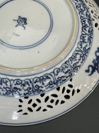 A pair of Chinese blue and white plates with floral design and reticulated border, conical shell mark, Kangxi